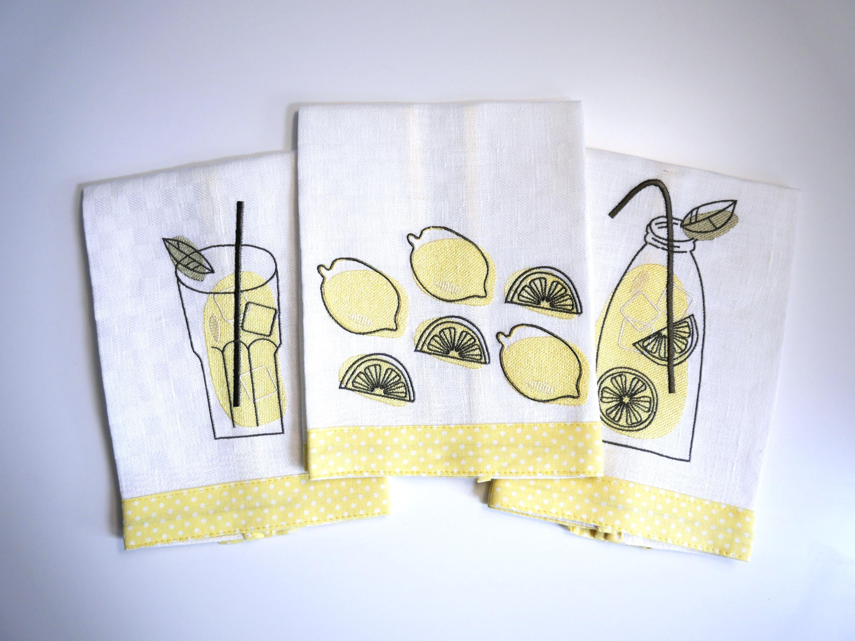 White kitchen towels embroidered lemons, lemonade and fresh limoncello.