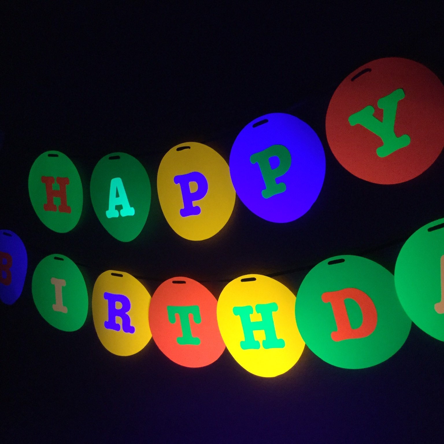 large 8 circle with letters to spell HAPPY BIRTHDAY in neon colors for glow black light party