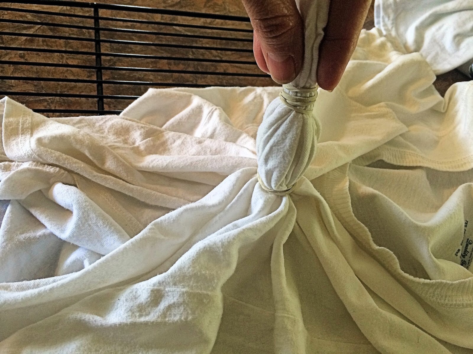 Shirt center pulled up and secured with a rubber band at the base