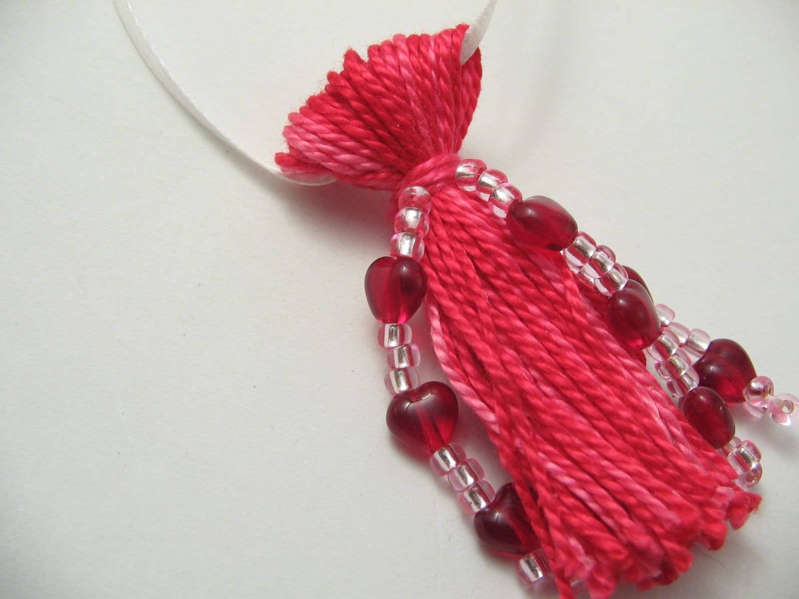 Pink tassel beaded with red glass hearts and white satin ribbon hanger