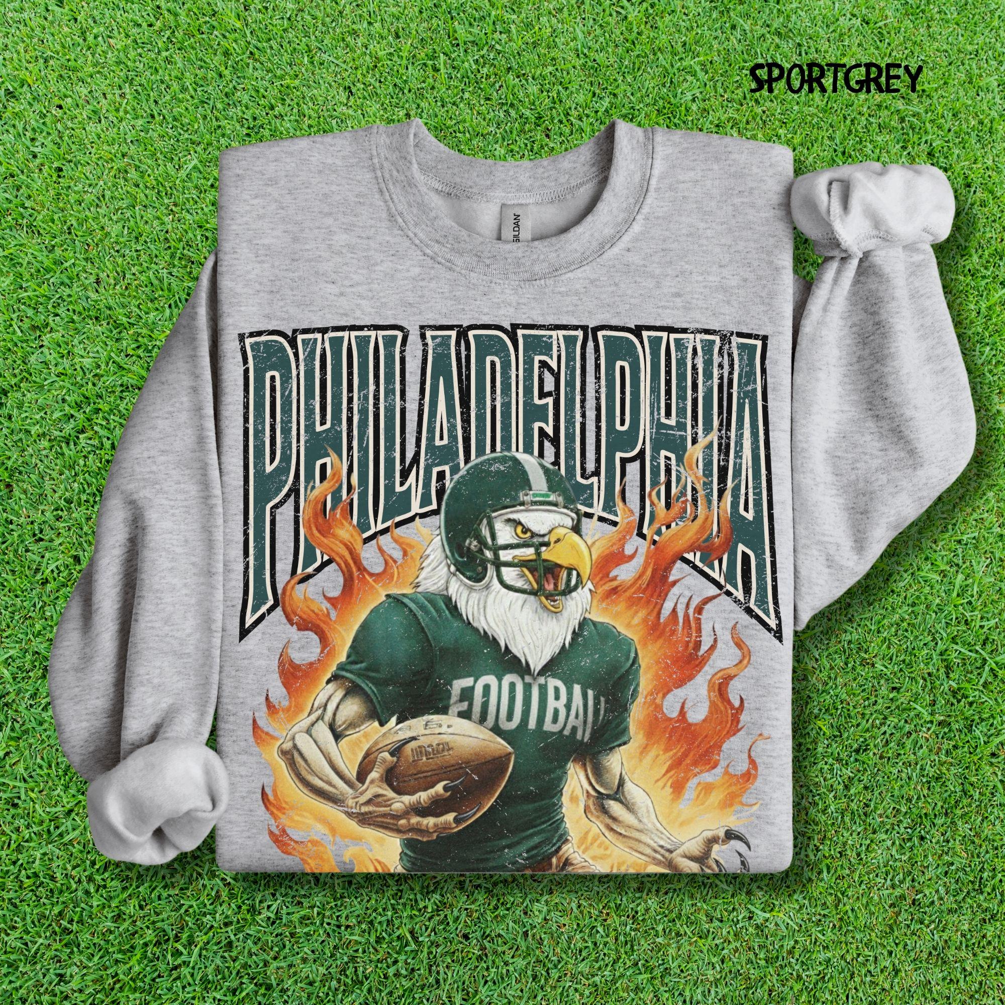 Sport Grey folded sweatshirt featuring the distressed vintage Philadelphia Football Eagle mascot graphic tee.