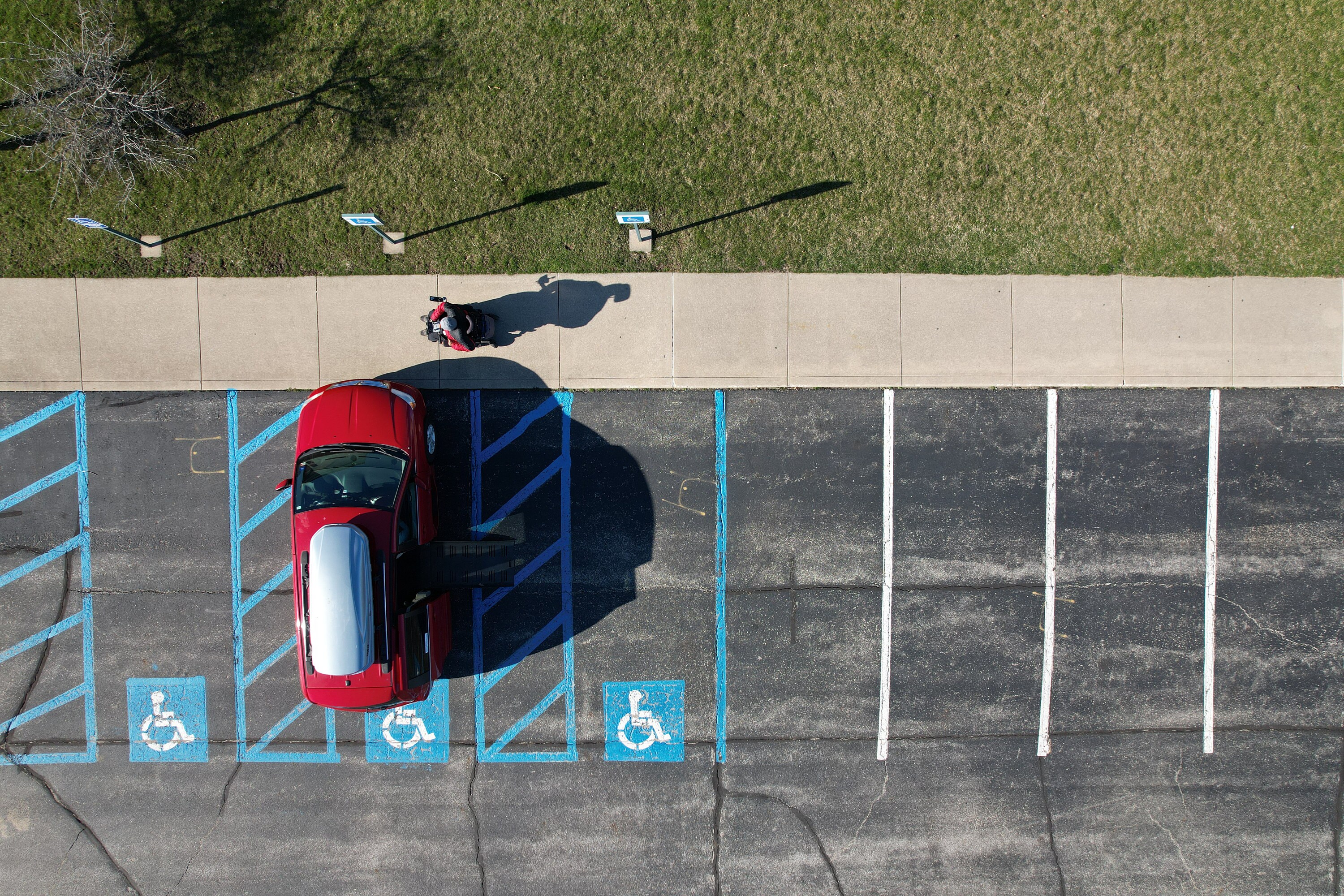 Ariel drone photographs showcasing a drone pilot in electric wheelchair with Brad accessible wheelchair van parked in handicapped parking