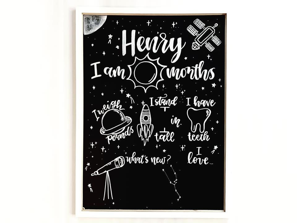 Pictured here is a space themed milestone chalkboard with white ink.