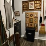 A small laundry room becomes a creative gallery, with cross-stitches and a vintage ironing board adding charm and function.