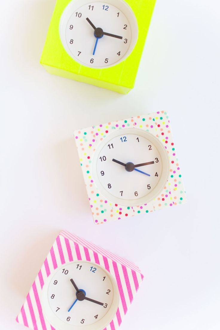 A clock on a table decorated with dotted and striped washi tape