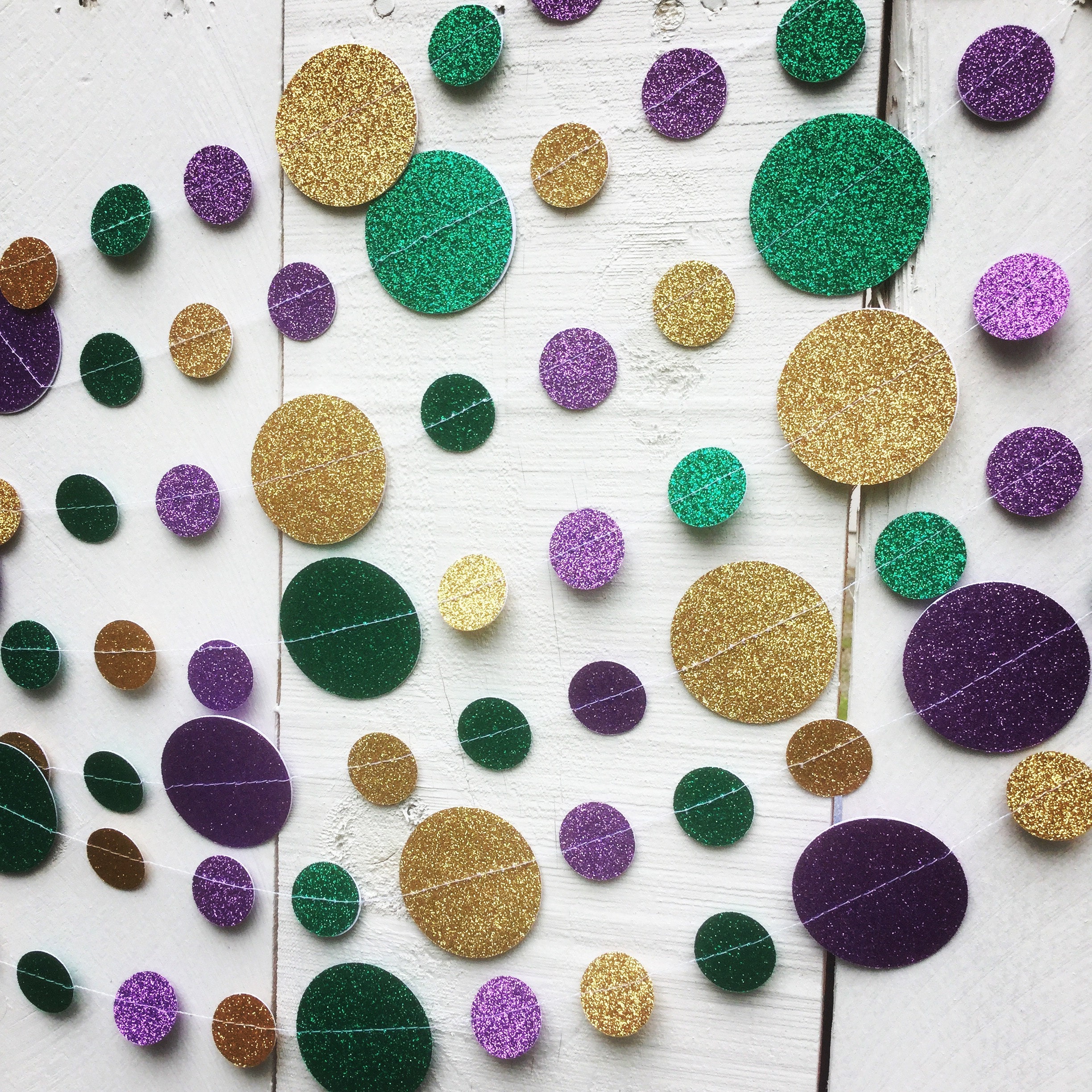 Green, gold, and purple glitter card stock circles sewn into a Mardi Gras garland decoration