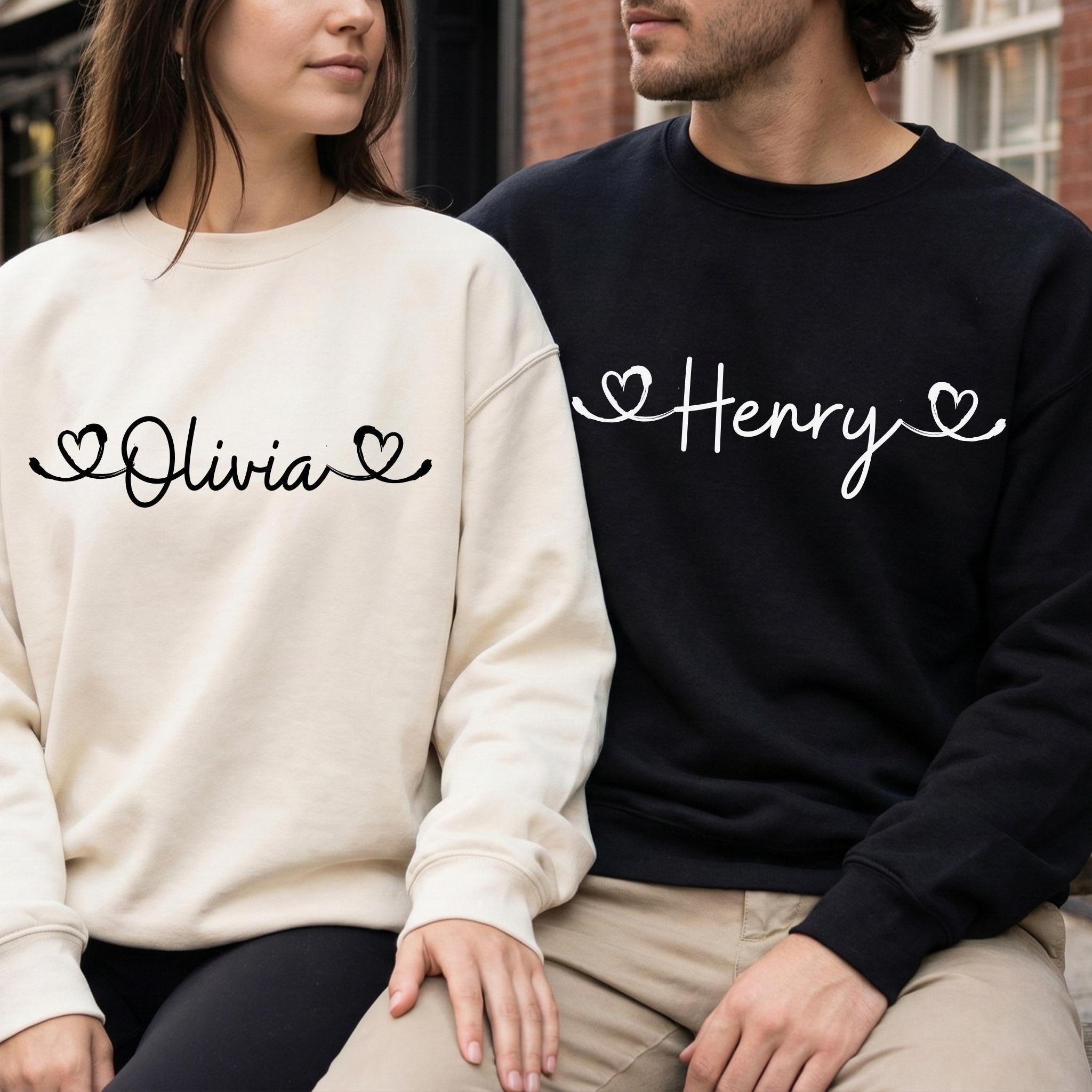 Personalized sweatshirts for couples, featuring heart-shaped lettering and custom names, perfect for Valentines Day.