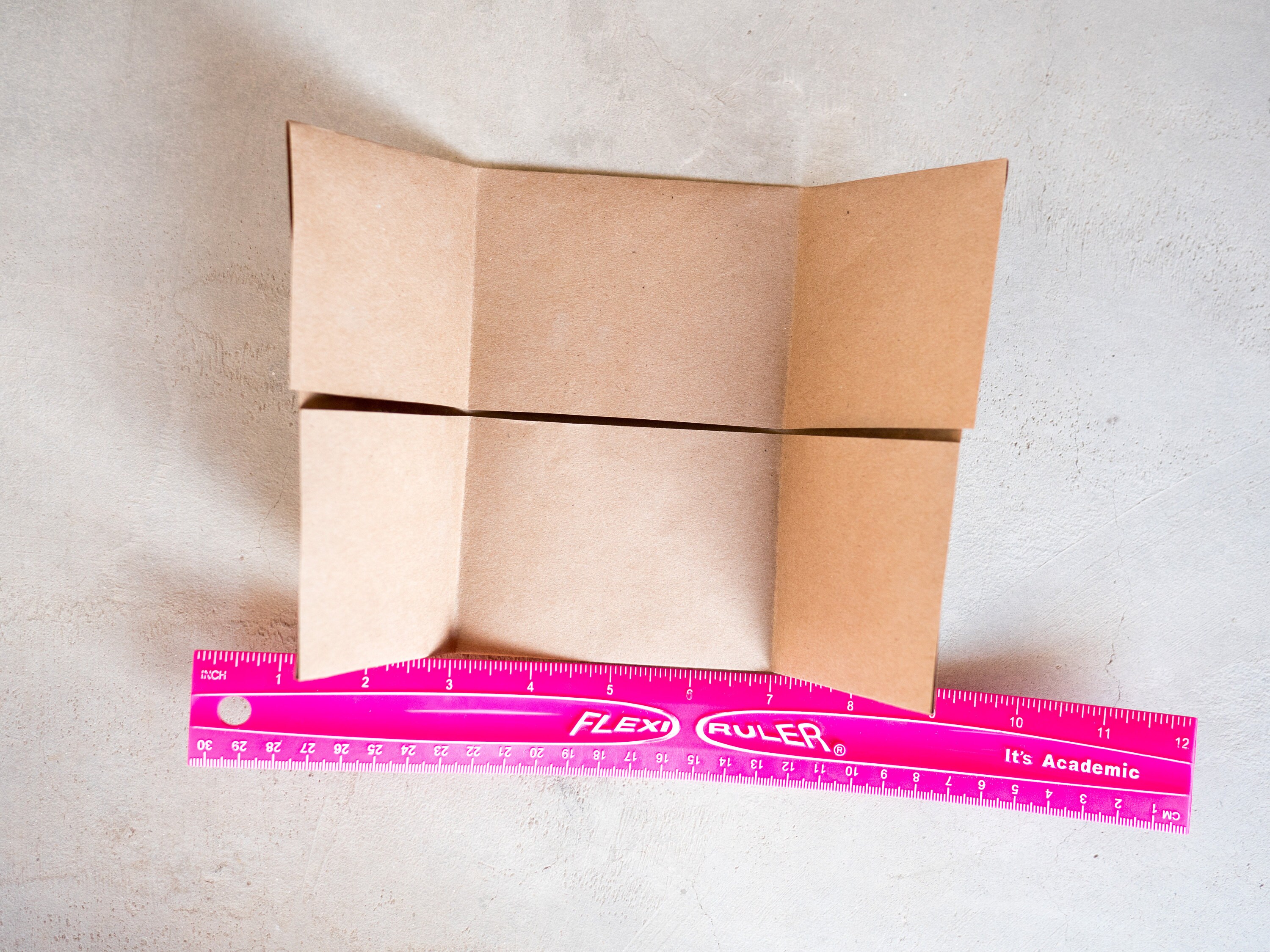 Turn so folded edge is facing you. Measure 3 inches from each end and fold those flaps toward the center. They will overlap.