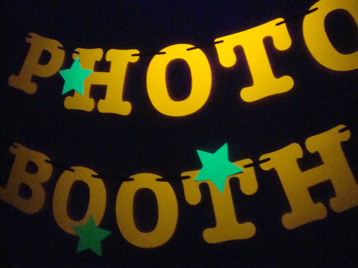 3.5 letters and stars in neon colors to spell PHOTO BOOTH
