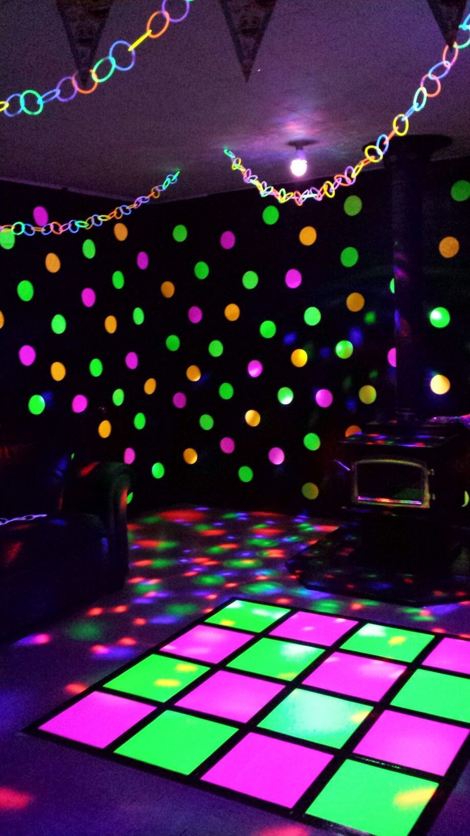neon poster board on dance floor at a glow black light party