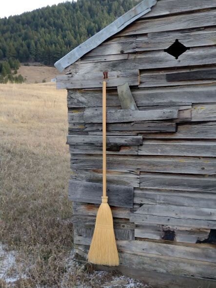 weathered outhouse broom