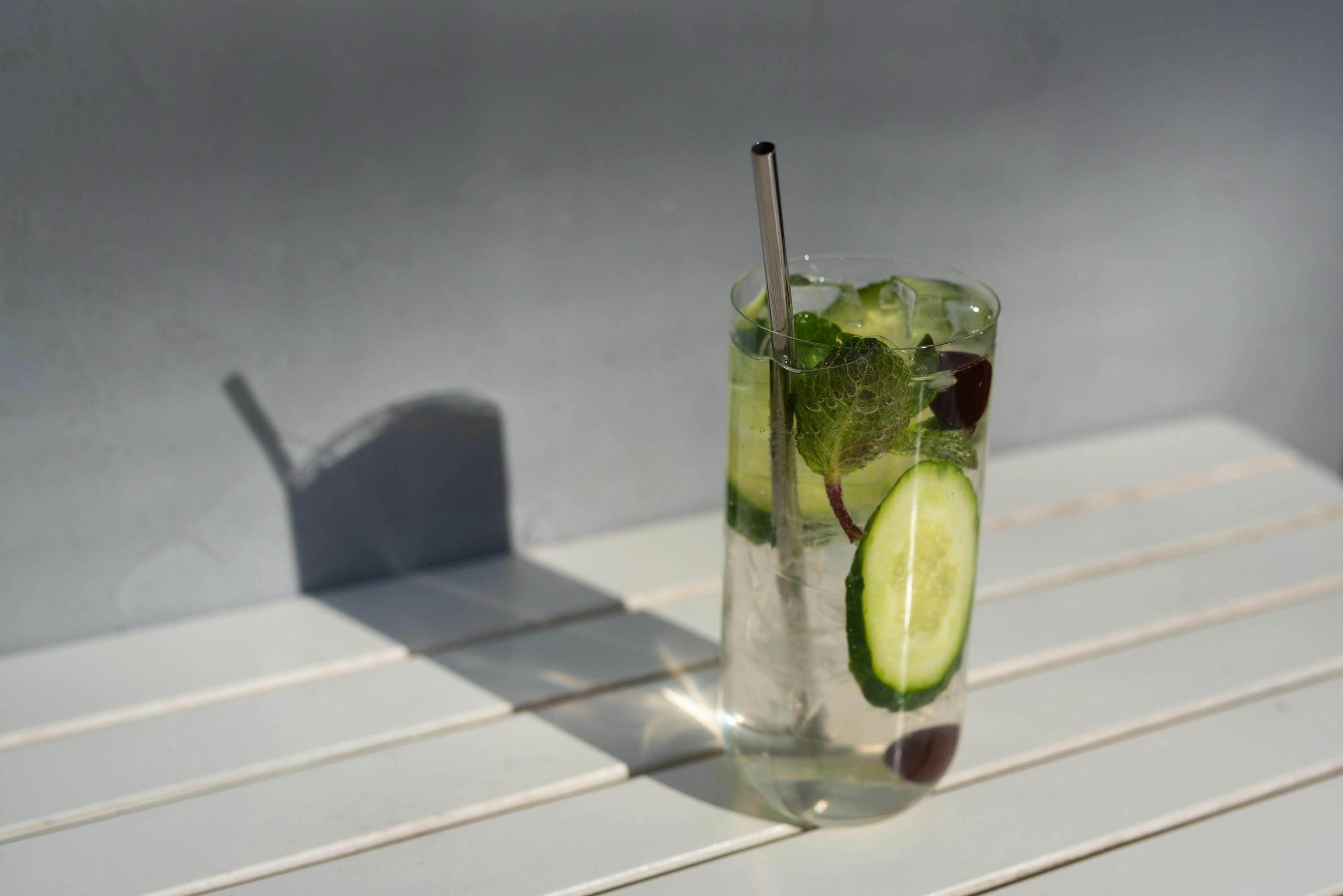 A glass of water with cucumber slices and mint