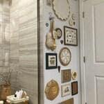 Guests often comment on Carolyn’s guest bathroom, where cross-stitches form a playful, wallpaper-like display.