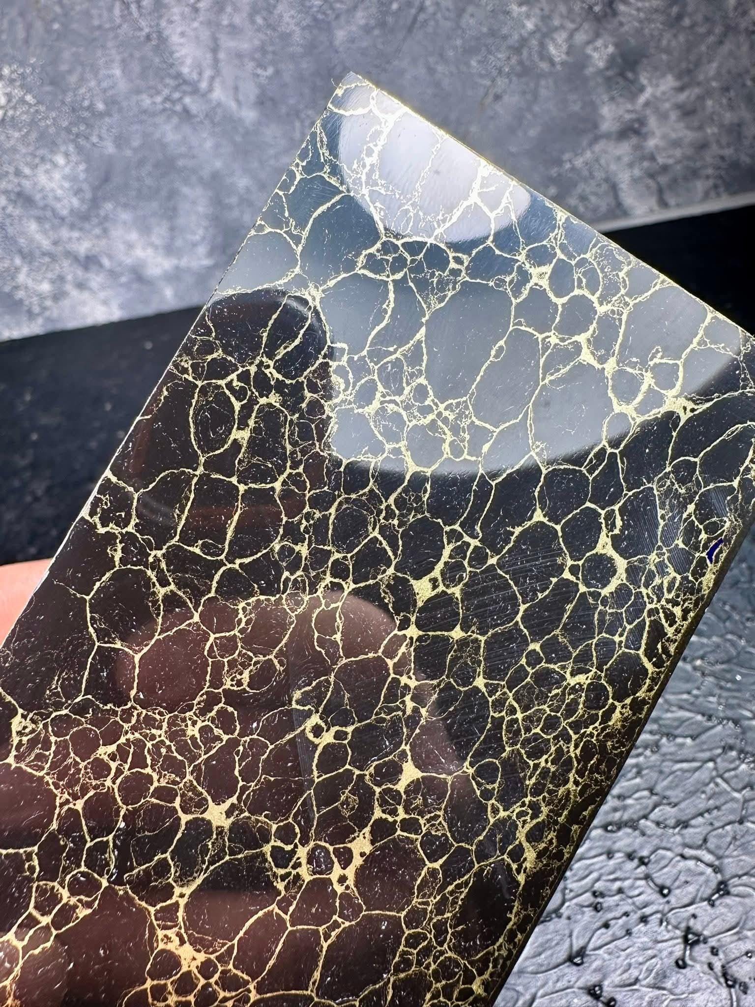 “Black obsidian style synthetic stone with gold vein network by Mohit Impacts, high contrast composite block for knives and luxury pens.”