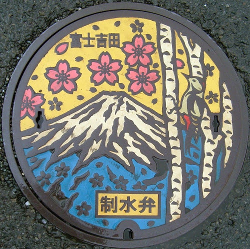 Plaque égout décorée mont Fuji fleurs cerisiers roses ciel jaune oiseau