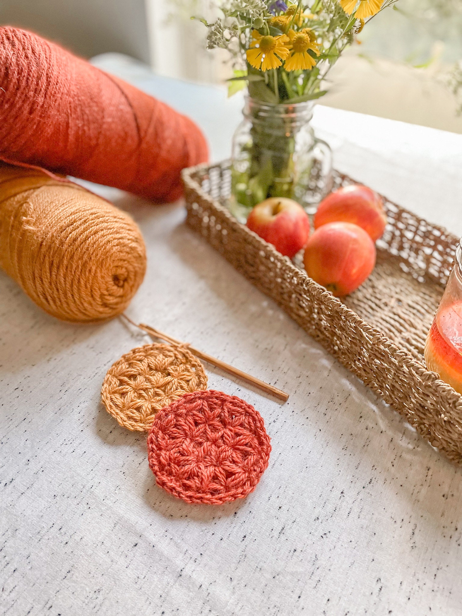 Crochet Fall Leaf Coasters, Yarn, Wildflowers, and apples in a basket
