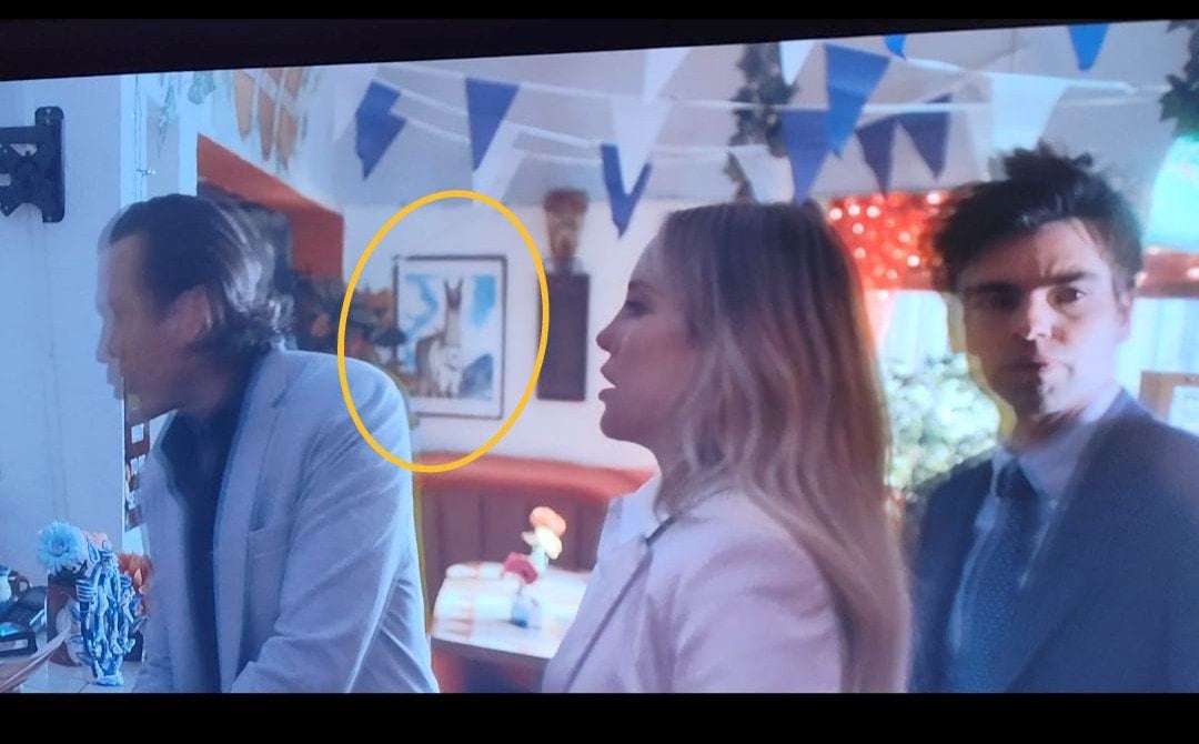 TV scene of the main characters entering the restaurant, with the Guanaco drawing highlighted.