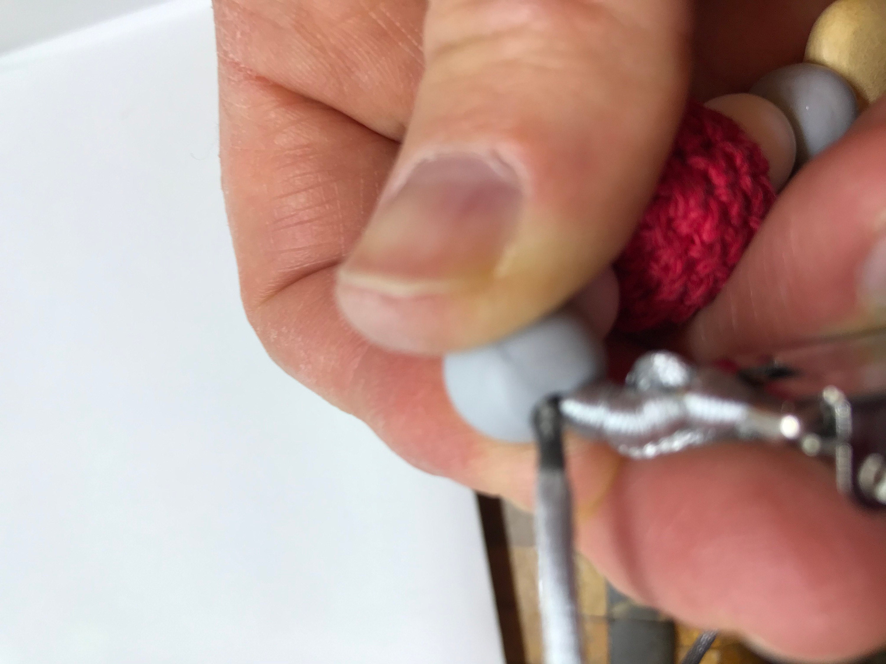 Pushing the tail back through the beads on the end.