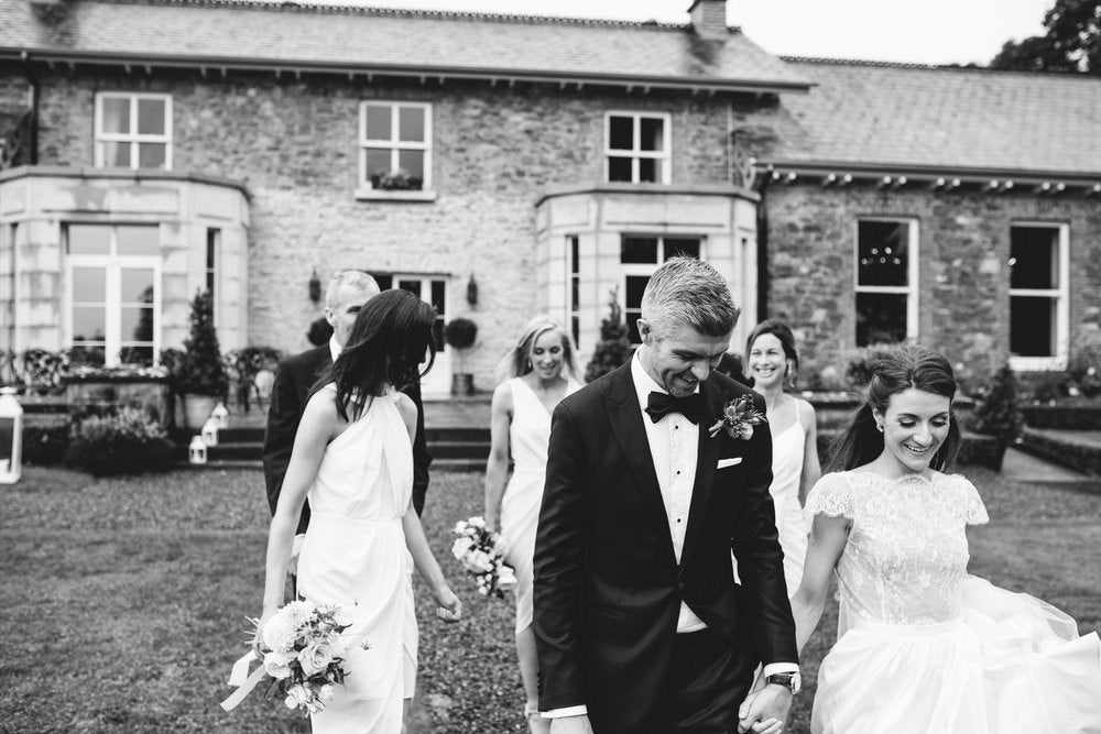 Black and white photo of the bridal party in front of a county lodge