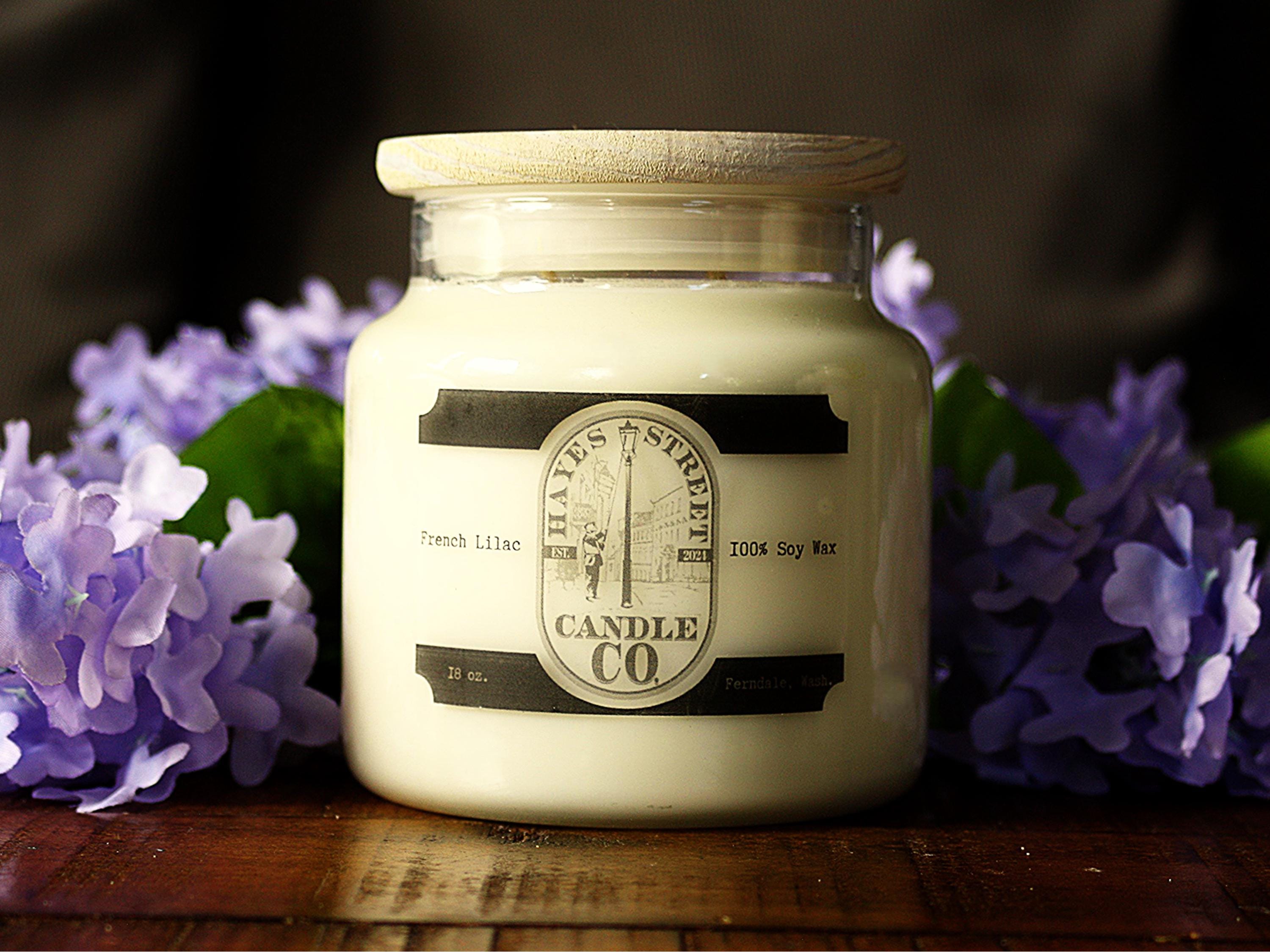 French Lilac candle by Hayes Street Candle Company in Ferndale, Washington, USA. This candle features two wicks and 18 ounces of undyed soy wax and fragrance oil. It is photographed with purple lilacs. There are some light spots Im trying to figure out how to get rid of.