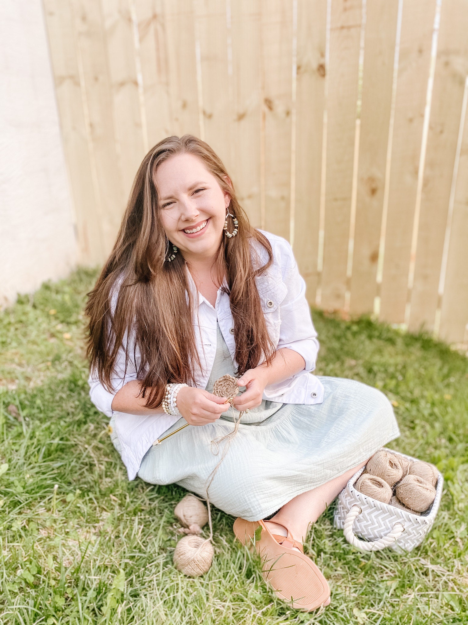 Woman sitting in the grass with a basket of yarn