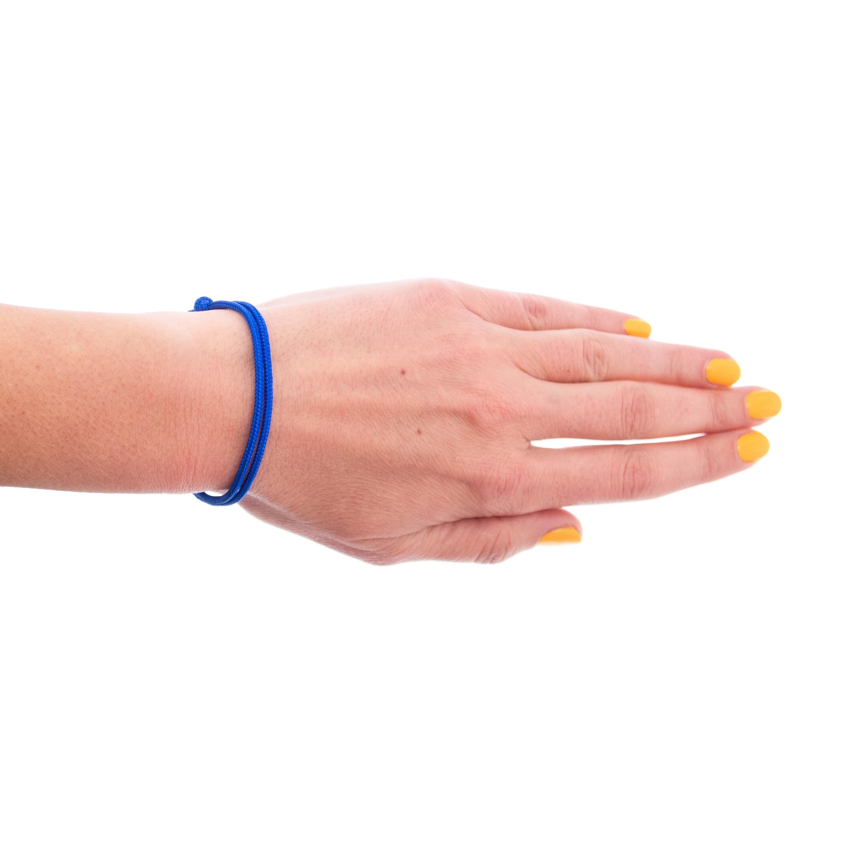 Hand wearing a blue rope friendship bracelet with sliding knot closure by Nadamlada