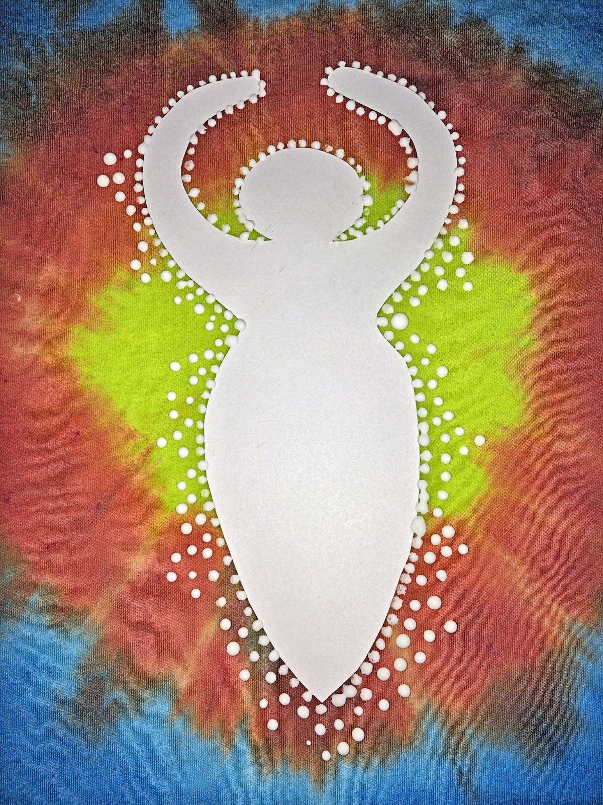 Varying sizes of white puffy paint dots radiating outward from the goddess shape