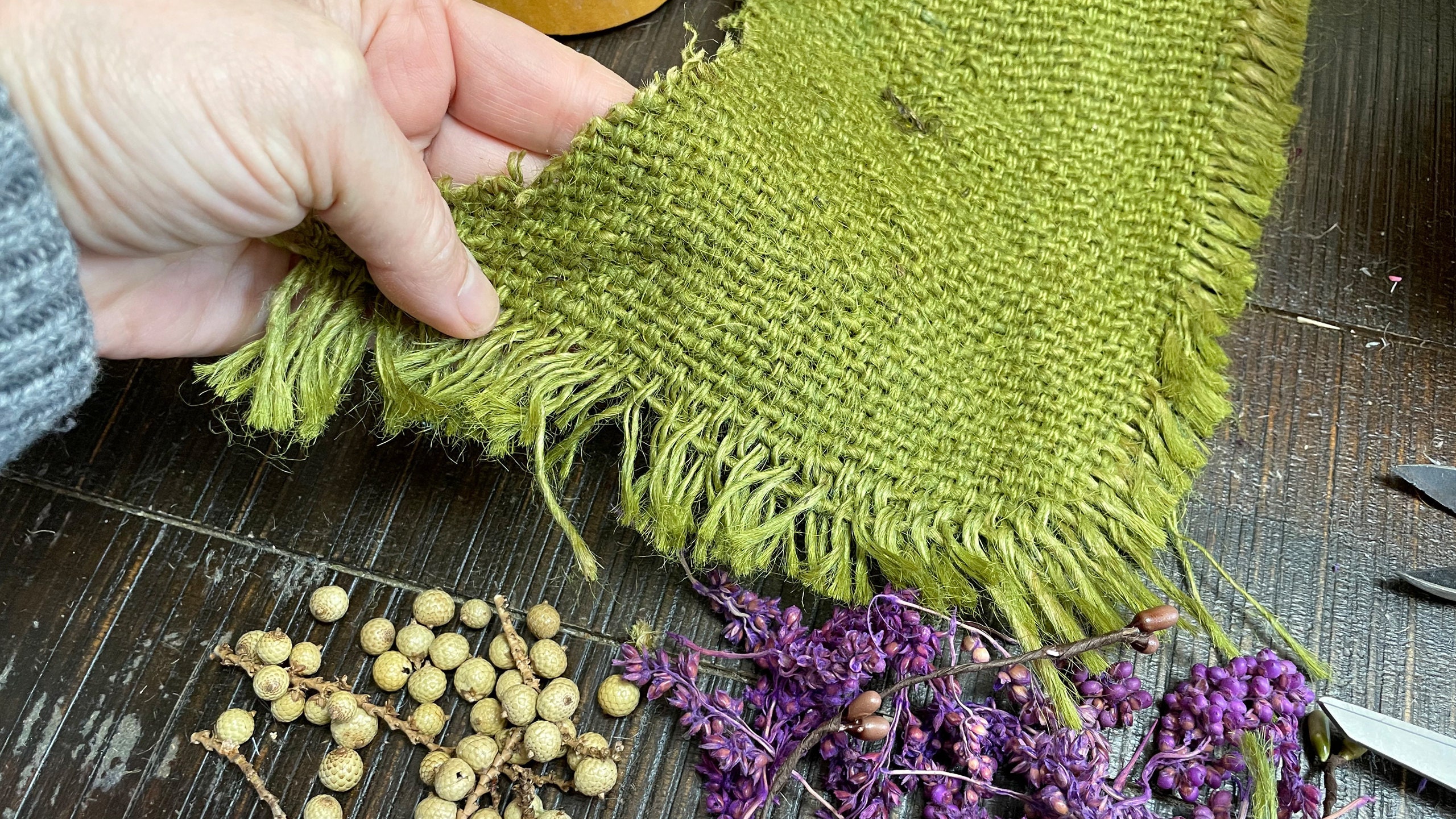 Upcycled coffee sack that has been dyed green. The fabric is used to make a handmade hat for carved gourd characters.