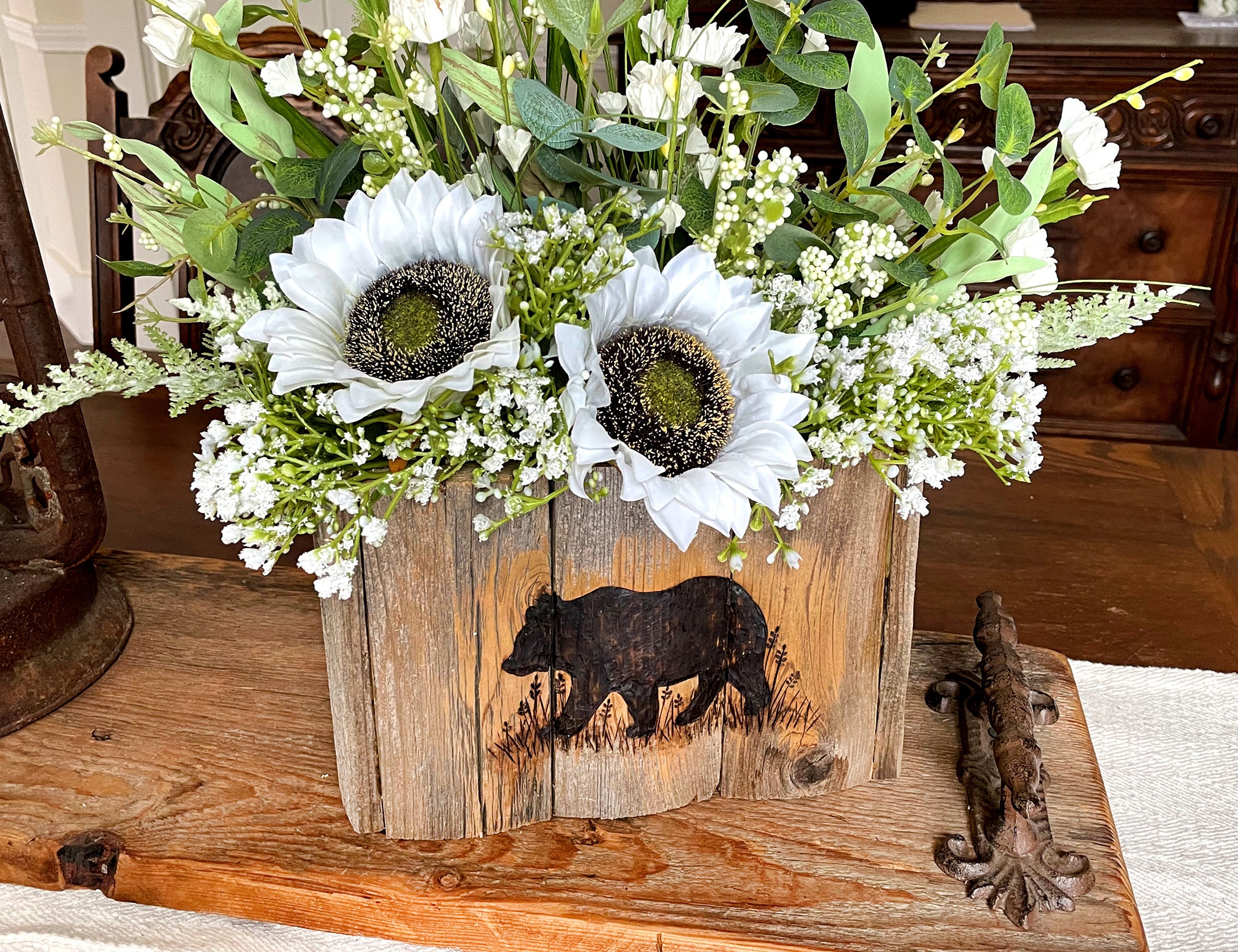 This image shows the handmade bear box vase with a faux sunflower arrangement. The box and flowers sit as a centerpiece on my dinning room table.