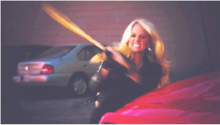 woman hitting red car with baseball bat