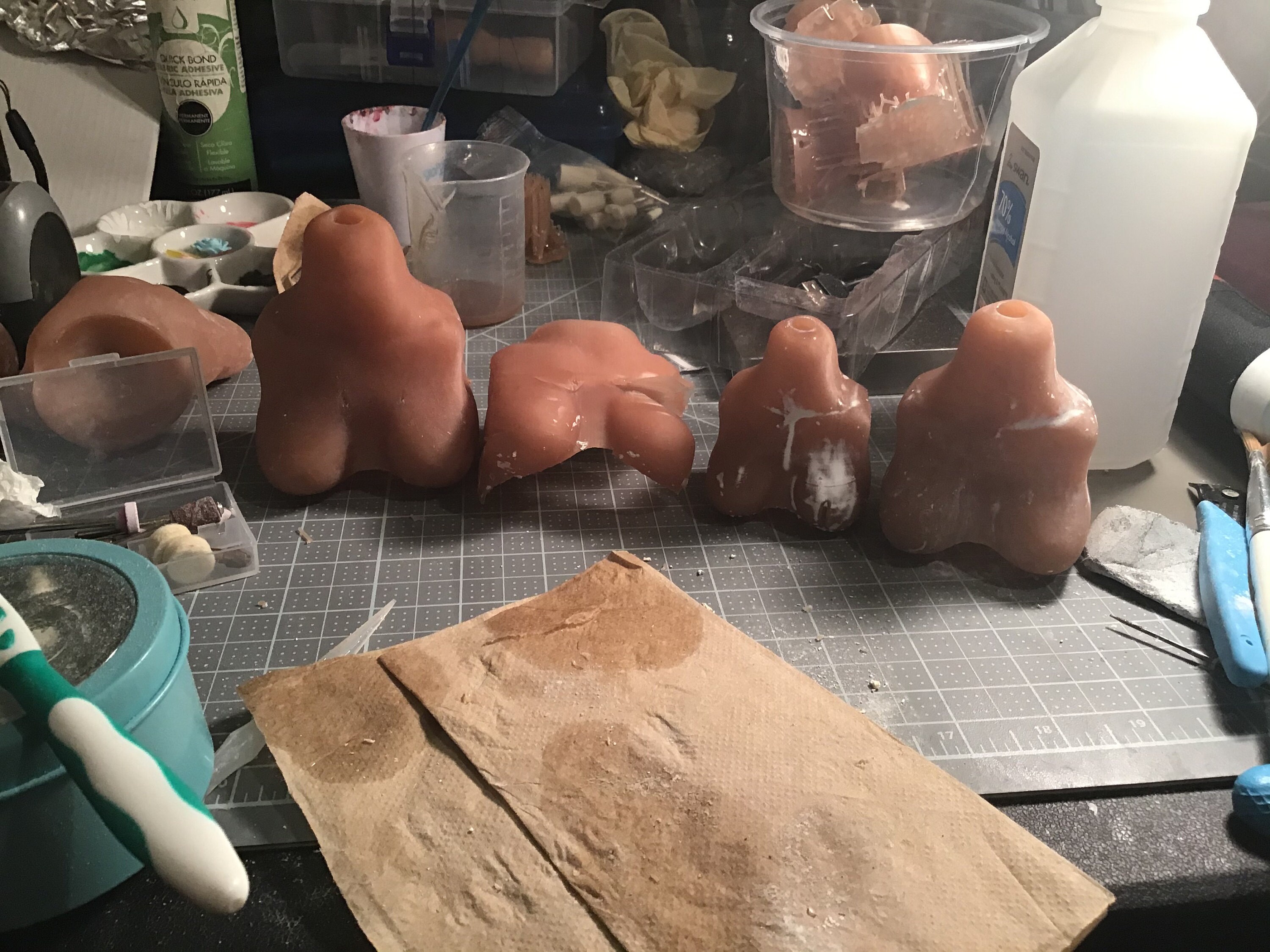 Image of 3D printed bust pieces in the color bright reddish brown. There are 4 of them in 4 different sizes. The first one is the biggest, the second one is the second biggest but was not formed correctly the third is the smallest, and the fourth is the second smallest.