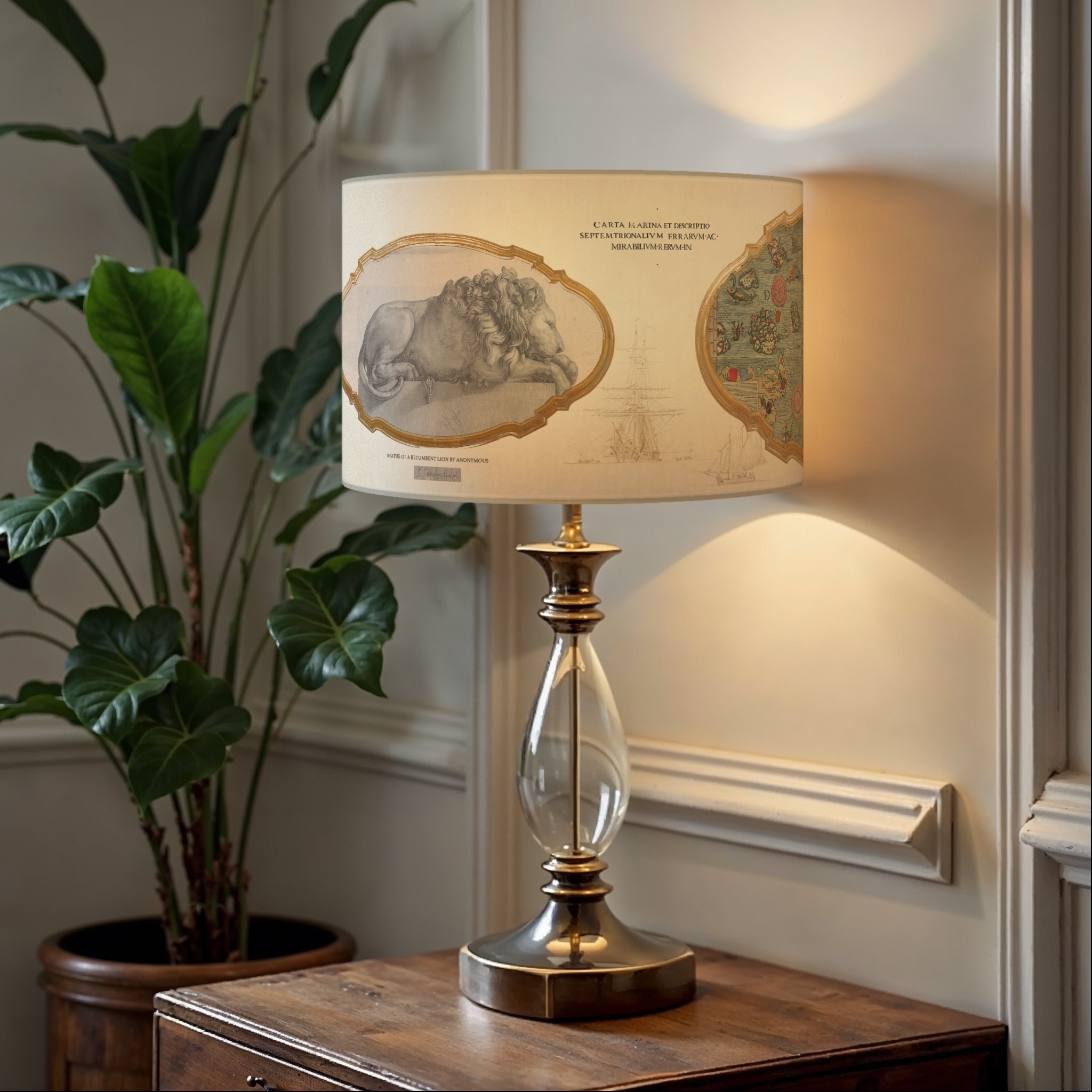 Lampe décorative avec abat-jour vintage Une lampe de table au pied en verre et métal doré, surmontée dun abat-jour orné dillustrations anciennes, dont un rhinocéros et une carte maritime. La lampe repose sur une table en bois rustique, avec une plante verte en arrière-plan, créant une ambiance élégante et nostalgique.