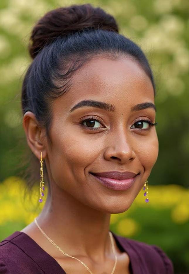 woman in burgundy dress wearing long chandelier style gold amethyst earrings